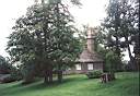 Pohled na kostel v Turaid smrem od hrobu Turaidsk re. Hrad Turaida je schovan za stromy v pozad