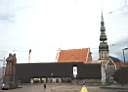 Nmst Lotyskch stelc, v pozad je ern budova Muzea okupace, za kterm se ty v kostela Sv. Petra. Socha rudch stelc je vidl nalevo